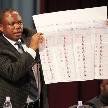 Corneille Nanga président de la CENI montrant un bulletin de vote